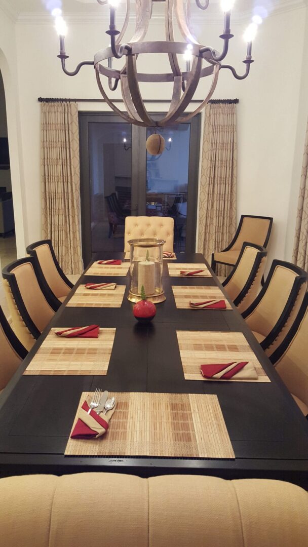 A dining room table with chairs and place mats.