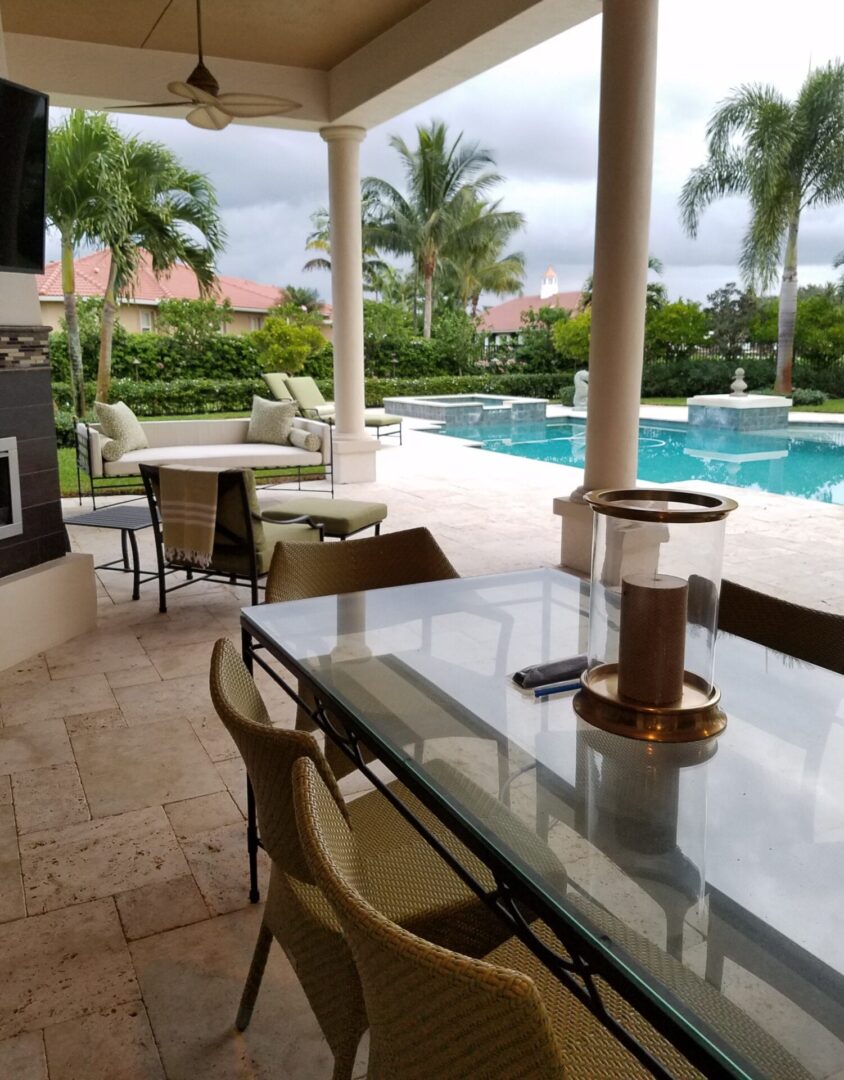 A table and chairs in front of the pool.