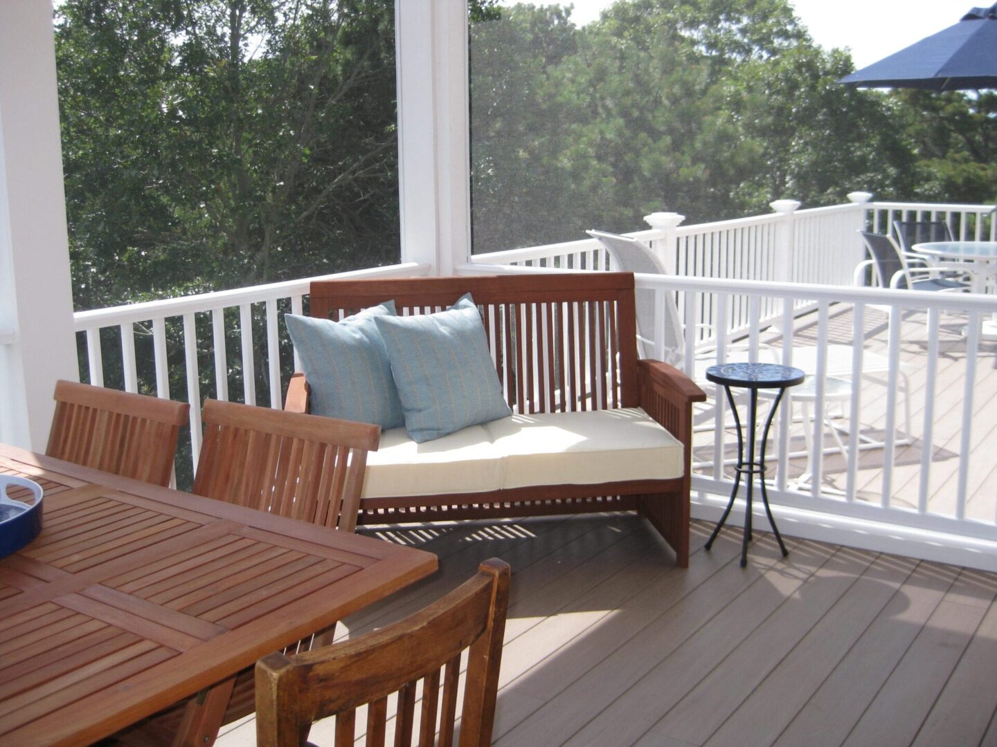 A porch with furniture and tables on it.