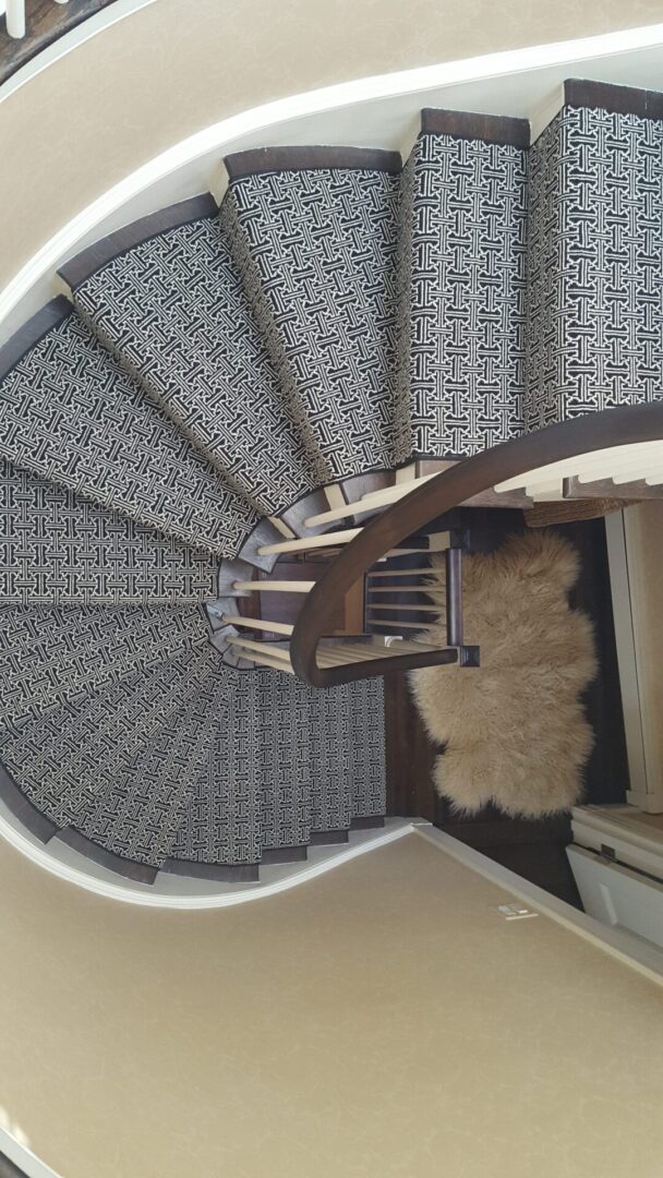 A spiral staircase with a rug on the bottom of it
